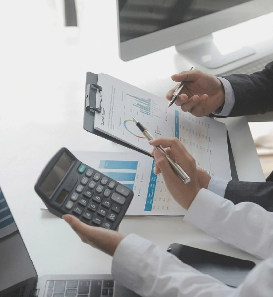 Close-up of a professional's hands typing on a laptop with a stethoscope resting on the desk nearby.
